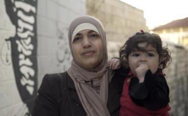امرأة أردنية متزوجة من رجل أجنبي، تحمل طفلتها، وهي واحدة من أبنائها الأربعة غير الحاصلين على الجنسية الأردنية. الصورة © أماندا بايلي لـ هيومن رايتس ووتش