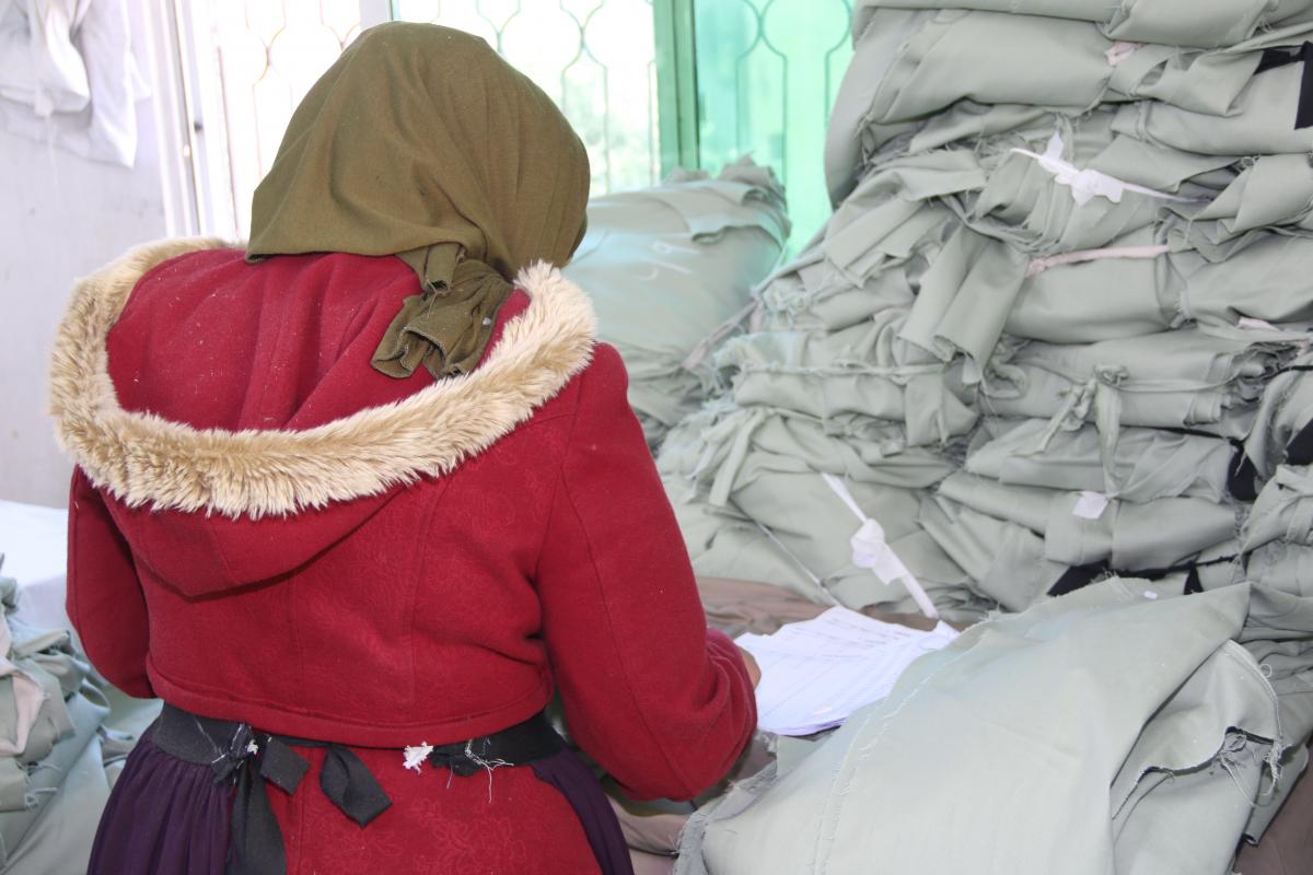 إحدى العاملات في مصنع الألبسة في كفرنجة.