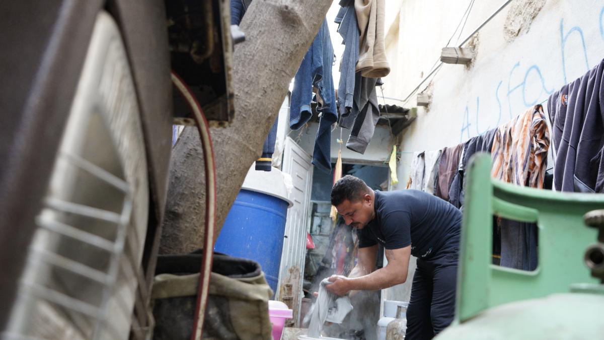 زهير يقوم بغسل الملابس على يديه وثم نشرها على الحبال