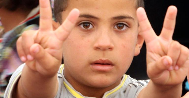 طفل سوري يرفع شارة النصر- عدسة حمزة مزرعاوي/ فيسبوك 