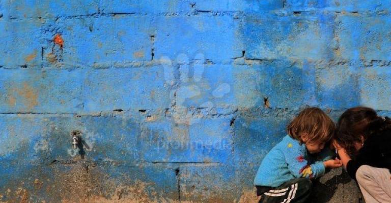 طفلان سوريان يلهوان بجانب جدار في الزعتري