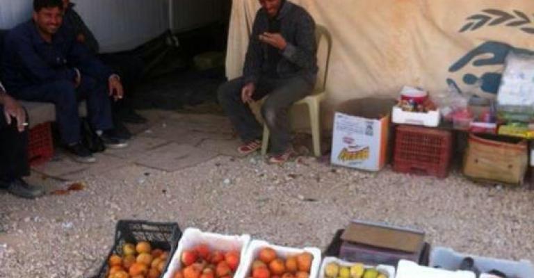 لاجئون يبيعون الخضراوات خارج خيامهم