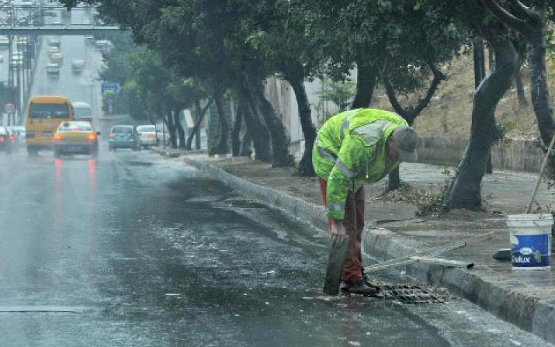 عامل يقوم بتنظيف مجاري التصريف في العاصمة- عدسة فارس خليفة/ فيسبوك 