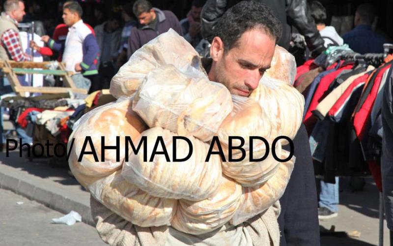 عامل مطعم في وسط البلد، محاصر بالخبز – عدسة احمد عبده/ فيسبوك 