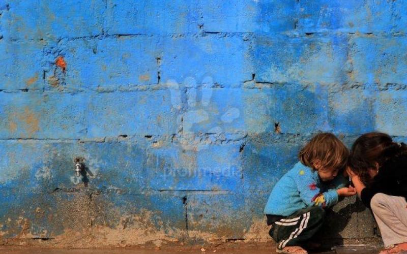 طفلان سوريان يلهوان بجانب جدار في الزعتري
